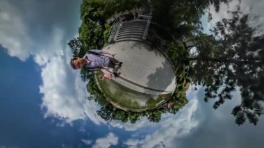 360vr Video baba ve çocuk yürümek yakınındaki sığ gölet baba elinde bir kamera yeşil yaz Park parke taşlar tarafından su güneşli gün bulutlar vardır yüzen üzerinde gökyüzü