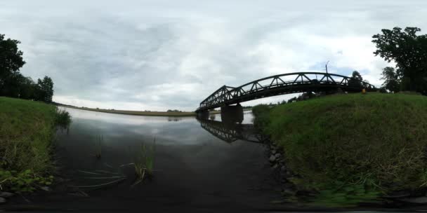 Vídeo 360Vr Pequena margem do rio Ponte de grama verde através de carros fluviais são impulsionados pela estrutura de água suave no lago Nuvens dia estão flutuando — Vídeo de Stock