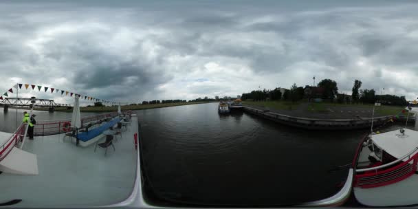 360Vr Video Barco de placer acercándose al banco Los niños viajan por el río Odra en el paisaje urbano de nubes gruesas de Opole en un día nublado de Horizonte — Vídeos de Stock
