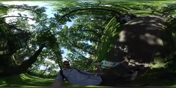 360vr video family dad taking video exkursion zoo opole kid walking along man in park alley people are sitting walking have a rest under green trees — Stockvideo