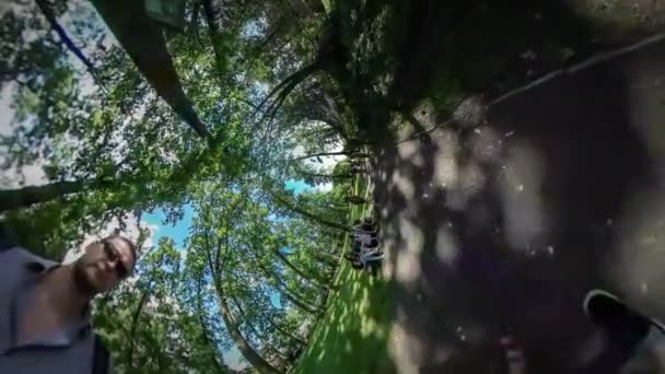 Caméra vidéo 360Vr avec caméra sur un bâton Excursion au parc Opole Papa marche avec sa fille par Park Alley Les gens Familles ensemble Arbres verts — Video