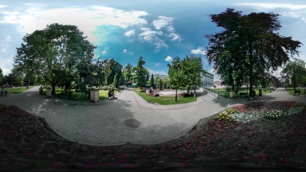 360 vr サンレミバスティオン ビデオ人が公園のベンチに座って歩いて木の花壇の間で緑の新鮮な木敷石青い空白い雲オポーレ ポーランド — ストック動画