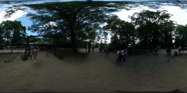 360Vr Video Niños en un columpio Día de la ciudad Opole Niños Los padres en el patio de recreo en el parque Las familias descansan caminando lentamente Sandy Ground Swings Escaleras Árboles — Vídeos de Stock