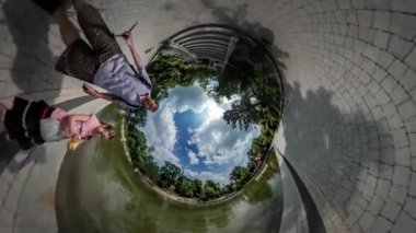 360vr Video baba ve çocuk oyun parke döşeme patika sığ gölet yeşil yaz Park yakınındaki ve banklar tarafından su güneşli gün bulutlar gökyüzü üzerinde yüzen
