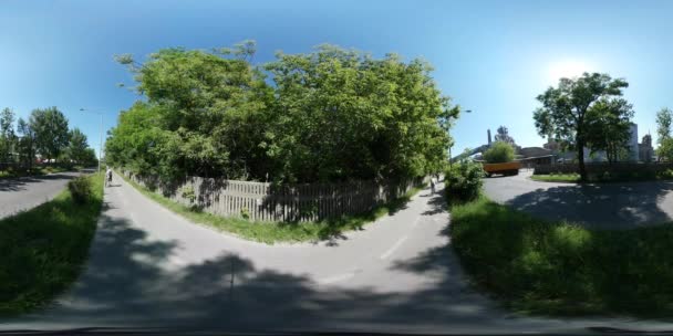 360vr videó ember vezeti a kerékpár mentén egy közúti autók teherautók kamionok város forgalom városkép épületek zöld pázsit és a fák a nyári napsütésben Opole — Stock videók