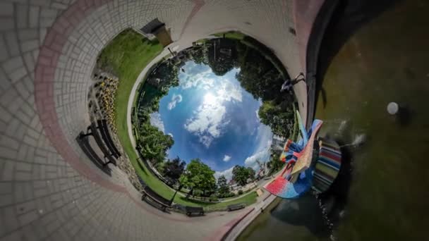 360vr Video vader en kind in de buurt van fontein stad dag Opole kleurrijke sculptuur in een stadspark familie besteedt tijd samen kind speelt met ballon zonnige dag — Stockvideo