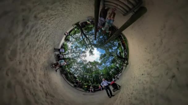 360 vr サンレミバスティオン ビデオ子供シリンダー遊び場市日オポーレ父と子供の両親が赤ちゃんを乳母車新鮮な緑木を日当たりの良い公園家族の遊び場で実行されています。 — ストック動画