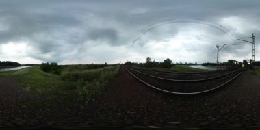 360vr yeşil alan demiryolu havai hat demiryolu elektrifikasyon sistemi cennet yeşil trenle yürüyen Video adam bir ufukta bulutlu gün yaz ağaçlar