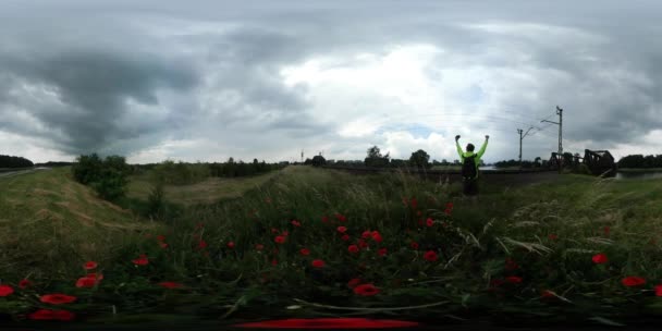 360vr βίντεο άνθρωπος στέκεται στο σιδηροδρομικό λαμβάνοντας Cloudscape σύστημα ηλεκτροδότησης σιδηροδρομικό βίντεο πράσινο πεδίο καταπράσινη δέντρα στον ορίζοντα μια συννεφιασμένη μέρα καλοκαιρινή — Αρχείο Βίντεο