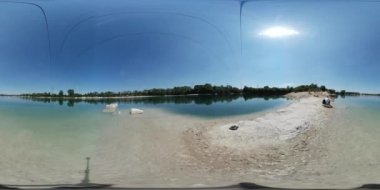 360vr Video adam kum küresel Panorama gökyüzü su erkekte alan vahşi doğa açık mavi gökyüzü güneşli günde yansıtılır su üzerinde oturuyor