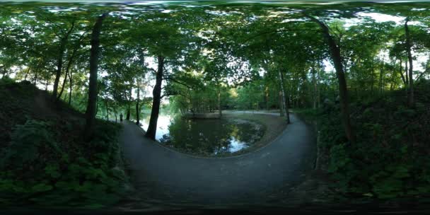 360Vr Video Sendero que cruza la bahía Panorama esférico El hombre está caminando por la carretera en el parque de la ciudad a lo largo del río o el lago Hora de verano Opole — Vídeos de Stock