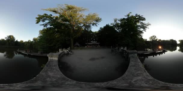 360vr wideo ludzi na molo panoramy sferycznej po obu stronach balkon kamienia brukowanych nabrzeże jeziora w parku miejskim — Wideo stockowe