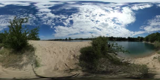 360 Vr Video Man Observing Sandy Bank of a Sea Leans Down Turquoise Rippling Water Backpacker is Walking Looking at the Water in Sunny Summer Day Green Bush — стоковое видео