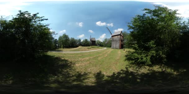 360vr Video twee molens in oude dorp houten stoffige weg voetpad Etnografisch Museum in Forest Green bomen gras gebouwen in een veld zonnige zomerdag — Stockvideo