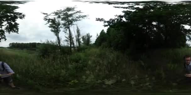 360Vr Vidéo Homme Touriste sur Green Overgrown Bank of River Lac des buissons verts Les arbres poussent sur une rive Backpacker marche Regardant la nature Nuageux Journée d'été — Video