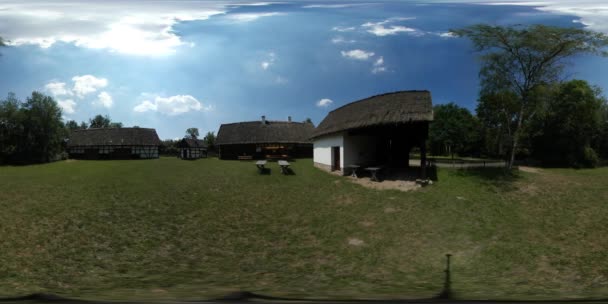 360vr Video altes Dorf rustikale Häuser Scheunen Tische unter Schutz Höfe grünen Rasen ethnographischen Museum im Wald grüne Bäume am Horizont Gras sonnig — Stockvideo