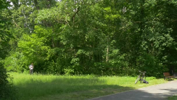 Mann mit virtuellem Tablet im grünen Park mit einem Tablet Zeit in der Natur verbringen frische grüne Bäume sonnigen Sommertag — Stockvideo