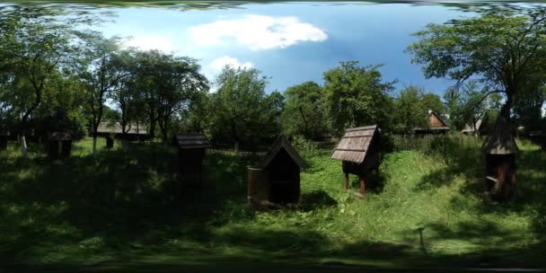 360vr Video bigården i gamla byn House formad bikupor består av trä bland träd rustika hus lummiga gröna träd skogen gräs solig dag blå himmel — Stockvideo