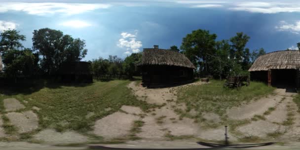 360vr Video-Touristen zu Fuß zwischen Hütten Häuser im alten Dorf beobachten rustikale Hütten Höfe sind mit Palisaden grünen Bäumen umzäunt Wald Gras sonnig — Stockvideo