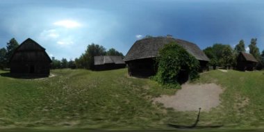 360vr Video turist arasında evler köy ihtiyar yürüme gözlemleyerek rustik evlerin sürünen bitki üzerine kapı avlu yeşil ağaçlar çim güneşli bir gün.