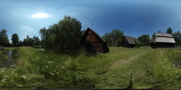 360Vr Video Hombre caminando cerca del lago Casas Museo Ramas de la aldea se balancean casa rústica Paisaje rural exuberante árboles verdes Estanque de césped Bosque Día soleado — Vídeo de stock
