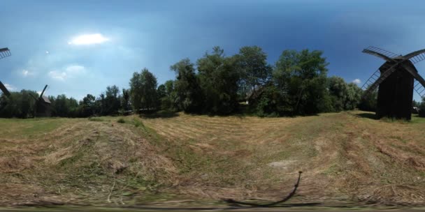 360vr Video mlýny ve středu pole staré vesnice venkovské krajiny rustikální domy s jejich dvorky suché seno na pole zelené stromy lesa slunečný den