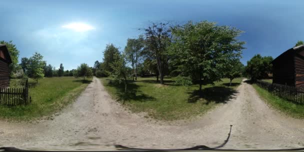 360Vr Vídeo Turista Caminhando por Dusty Crossroad Cottages Old Village Observando Casas Rústicas Com Seus Pátios Árvores Verdes Gramado Floresta Dia ensolarado — Vídeo de Stock