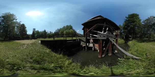 360vr Video člověka pěší most vodní mlýn staré vesnice cestovního ruchu je pozorování rustikální jezero dům s jejich dvorky zelené stromy trávník lesní slunečný den — Stock video