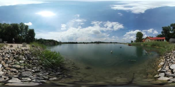 360vr film człowiek wspina się turystycznego jeziora rzeki budynek dworca Stony Bank łódź jest chodzenie od drzew zieloną na słoneczny dzień z horyzontu na gładkiej wody — Wideo stockowe