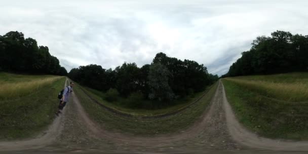 360Vr Video Hombre caminando por el sendero Backpacker Tourist se está filmando a sí mismo sosteniendo la cámara en un palo Los árboles verdes están junto a los lados del sendero Día nublado de verano — Vídeo de stock