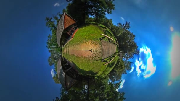 Little Tiny Planet 360 Grau Pequena Ponte de madeira sobre a grama verde Gully e árvores telhados de palha sobre as casas rústicas Linda aldeia tranquila — Vídeo de Stock