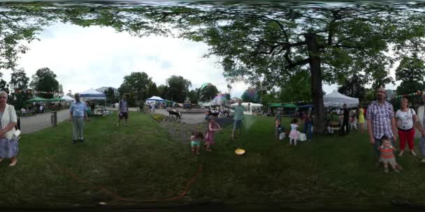 360Vr Video Niños Jugando en una Ciudad de Hierba Día Opole Square Tiendas Sillas Mesas al aire libre Familias Madres Papás y Niños Pasan Tiempo Juntos Nublado Día de Verano — Vídeos de Stock