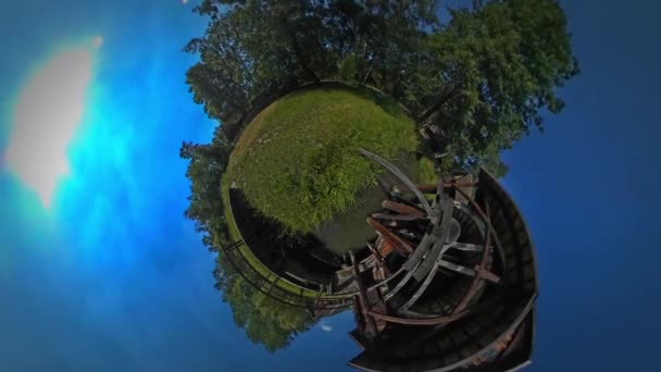 Pequeño planeta 360 grados puente de madera sobre el pequeño lago hermoso pueblo campo casas antiguas graneros cobertizos y corral cielo azul claro — Vídeos de Stock