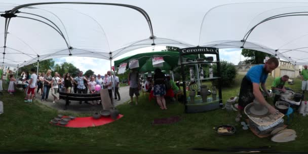 360Vr Vídeo Artesãos Fazendo um Potes Opole Dia das Crianças As pessoas estão olhando para a Feira Sob Tenda em um gramado verde Pessoas Divirtam-se Famílias Crianças — Vídeo de Stock