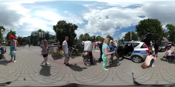 360vr відео людей на дитячий день Ополе поліція автомобіль аніматор клоун людей, гульки їзда на велосипеді, ходьба з дітьми на квадратний святкування — стокове відео