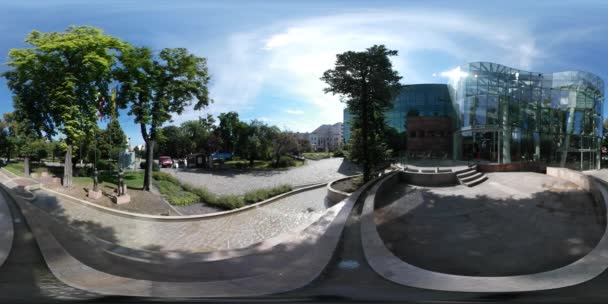 360vr Video sochy lidí na náměstí parkovat auta uličky jsou řízený moderní budova v parku zelené stromy slunečný den ukrajinské a polské vlajky mává — Stock video