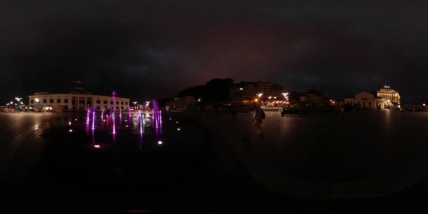 360Vr Video Man on Postal Square Fontes coloridas Kiev Toques Iluminados Jatos de água Velhos Edifícios Backpacker Olhando para as vistas no céu escuro à noite — Vídeo de Stock