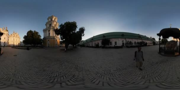 360Vr Vidéo Homme Près du clocher Pièce de vieux mur Cobblestone Kiev Pechersk Lavra Square Tourist is Looking at Historical Religious Buildings crépuscule Coucher de soleil — Video