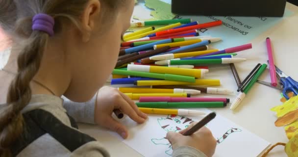 Tijeras, bolígrafos y lápices de colores yacen sobre una mesa — Vídeos de Stock