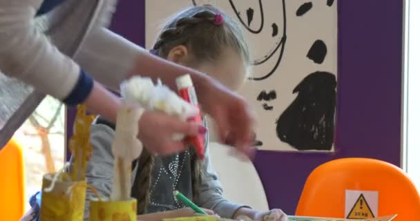 Маленькая девочка рисует цветными карандашами на уроке рисования — стоковое видео
