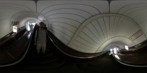 360vr video människor på rörliga trappa komma ner på underground station Kiev City Day man håller kameran på en pinne filma Panorama Dome tak — Stockvideo