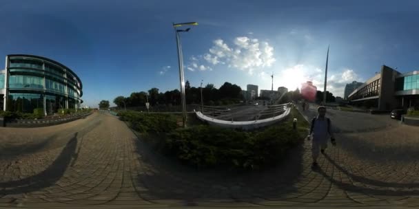 360Vr Video Man Filmación Panorama Glass Building Bridge Kiev Cityscape City Day Puente peatonal de adoquines en los rayos del atardecer Los coches son conducidos por la noche de verano — Vídeo de stock