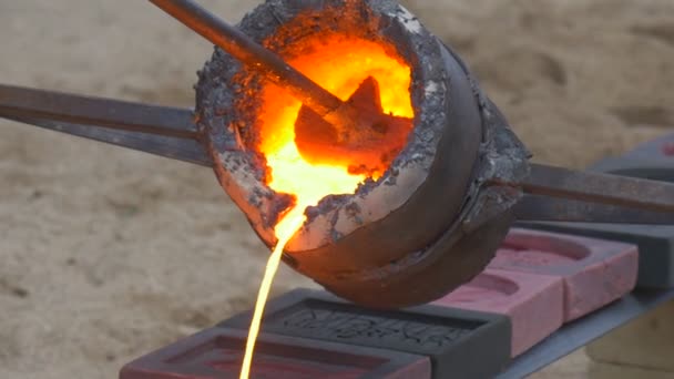 钢铁成型工艺 工人们正在小心翼翼地迅速地把熔融的金属倒入熔体 直到熔体变硬 液体橙是圆形和正方形的 工人们穿着安全衣服 — 图库视频影像