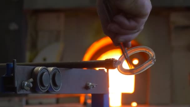 Mannen ger runda Form till ett glas halvfabrikaten med hjälp av en liten metall pincett — Stockvideo