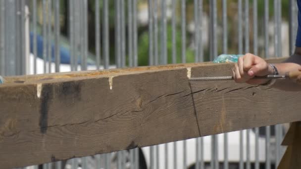 De Man Sawed ondiepe putten in een houten plank met hulp van een handmatige bestand — Stockvideo