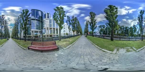 360Vr Vídeo Personas caminando por la avenida Taras Shevchenko Prospecto en Kiev Banco individual en callejón Árboles verdes brillantes Césped Los coches son impulsados por el sol edificio de vidrio — Vídeos de Stock