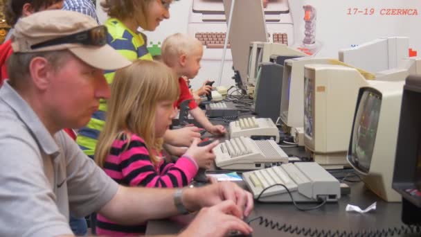 Νέων και ενηλίκων ατόμων παίζει σε υπολογιστή δωμάτιο κατά τη διάρκεια που μεταφέρουν από το διαγωνισμό «ρετρό παιχνίδια υπολογιστή» στο Wroclaw — Αρχείο Βίντεο