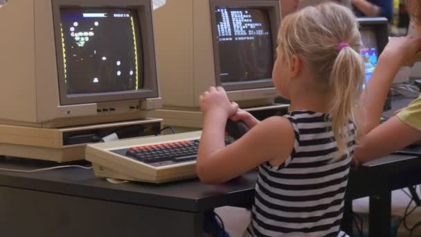 Το μικρό ξανθό κορίτσι παίζει παιχνίδια υπολογιστή με το Joystick βοήθεια — Αρχείο Βίντεο
