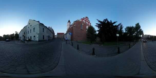 360vr Video Menschen in der Nähe der Kirche Glockenturm Platz Opole Stadt Tag alte Gebäude Abend Stadtbild in der Dämmerung Oldtimer Autos werden Fußgänger gefahren — Stockvideo