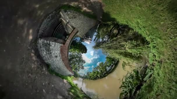 360 Degree Rabbit Hole Planet Abandoned Building on a River Bank Sunny Summer Day in Park Willow Tree Branches Trees on Opposite Bank of River White — Stock Video